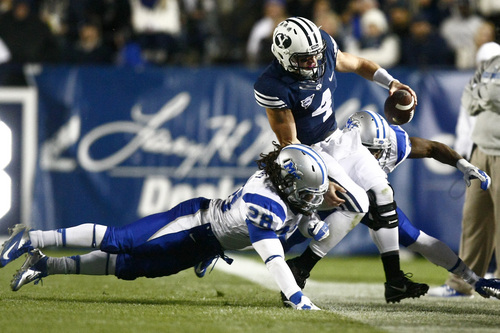 Chris Detrick  |  The Salt Lake Tribune
Brigham Young Cougars quarterback Taysom Hill (4) is tackled by Middle Tennessee Blue Raiders linebacker Christian Henry (28) and Middle Tennessee Blue Raiders linebacker Leighton Gasque (40) during the first half of the game at LaVell Edwards Stadium Friday September 27, 2013. BYU is winning the game 23-10 at halftime.